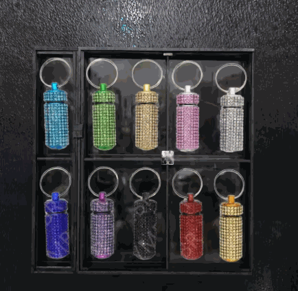 Compact rhinestone-covered Bling Pill Storage Keychain with twist-top capsule and metal ring in rose gold color