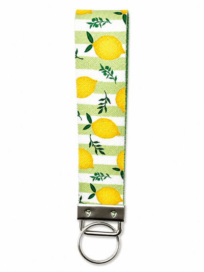 Printed wrist strap keychain with colorful playful patterns and metal clasp on white fabric