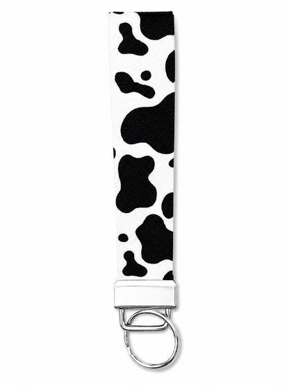 Printed wrist strap keychain with colorful playful pattern and metal clasp on white fabric background
