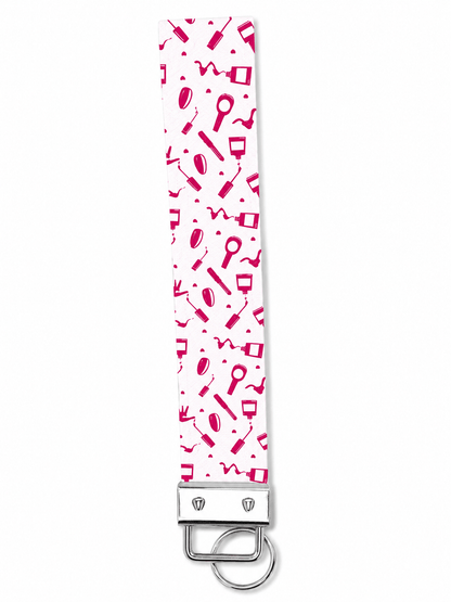Printed wrist strap keychain with colorful playful patterns and metal clasp on white fabric background