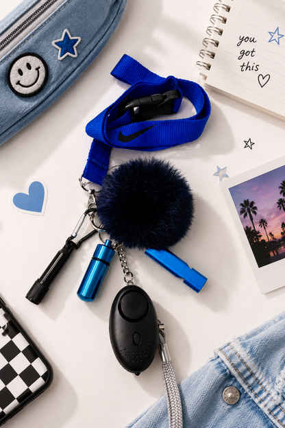 Confidence Club Safety Kit with blue lanyard, black personal safety alarm, blue safety whistle, black contactless tool, and navy pom-pom keychain
