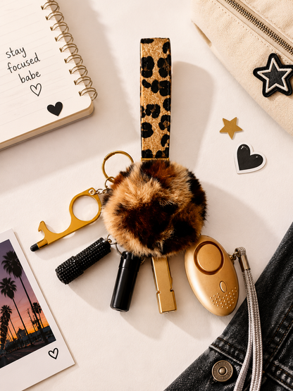 Confidence Club Safety Kit featuring leopard print pom-pom and wristlet with gold and black personal safety tools and accessories